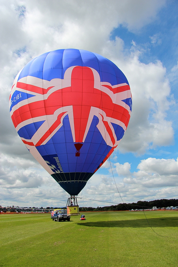 Our new Union Jack Hot Air Balloon is a Lindstrand with a volume of just 77,000 cubic feet, less than a fifth of the size of our biggest balloons and carries just two passengers and pilot. It is available for exclusive flights for two, film and location work, television etc. Prices start from &pound;600, so to fly in our Union Jack hot air balloon call us on 01252 844222 for more details. We are really looking forward to flying this fabulous balloon very soon.
Thanks to Lindstrand Media for providing this great picture of them displaying the balloon in 2012 at the Oswestry Queens Jubilee Celebrations