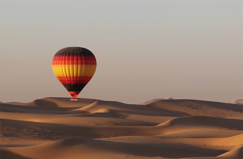 Get a glimpse of the bird&rsquo;s eye view from the hot air balloon basket into the heart of the desert with its uninterrupted desert vistas and rolling red dunes. Rising early for a sunrise flight and watch the sun creep over the horizon creating spectacular visual images over the dunes below. Spot wandering camels, gazelles or oryx that roam the conservation area, maybe meet up with falconers or farmers as you land for great photographic memories. Enjoy some cold refreshments after touch down as your balloon pilot presents you with your flight certificate and then head back into Dubai where you will be dropped off to enjoy the rest of your day.