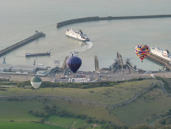 Three hot air balloons on a flight over Dover Harbour