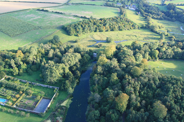 A Hampshire country house walled garden and miniature castle at end of lake.