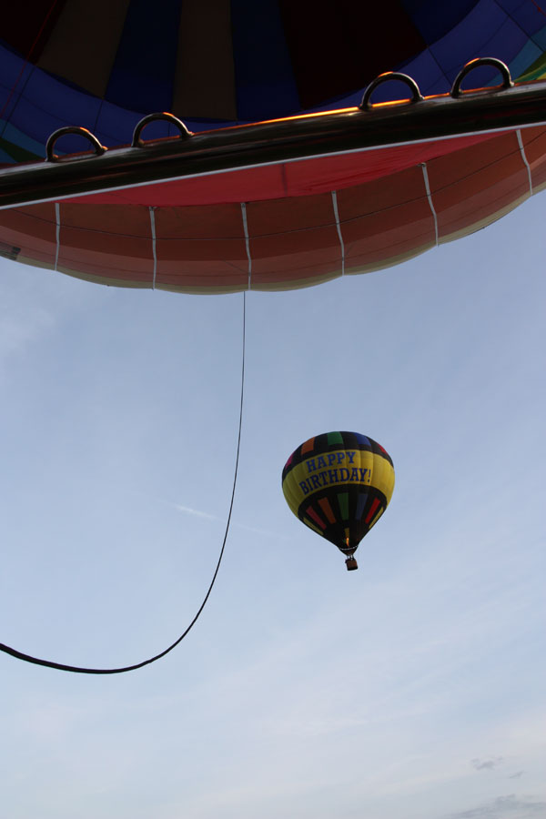 When we fly our balloons together there is always the chance of some pictures with both balloons in the picture. Here our Happy Birthday balloon floats a few hundred feet above the top of another of our fleet of hot air balloons