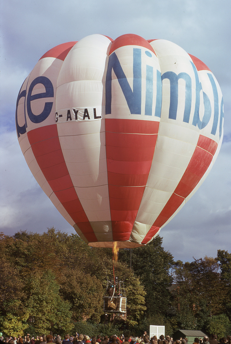 Nimble Balloon G-AYAL flying from Cheddleton Hospital, Leek, Staffordshire on the 21st October 1973. The pilot is waving to the onlooking crowd as the balloon rises from the ground on its balloon flight. The TV adverts which gave rise to the three balloons were at their peak around this time. Another picture kindly provided by Peter J. Bish. These days, if you would like to fly in a hot air balloon over Staffordshire you had best try www.wickersworld.co.uk