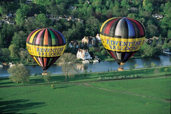 Two of our hot air balloons cross the River thames by the Reading Festival site